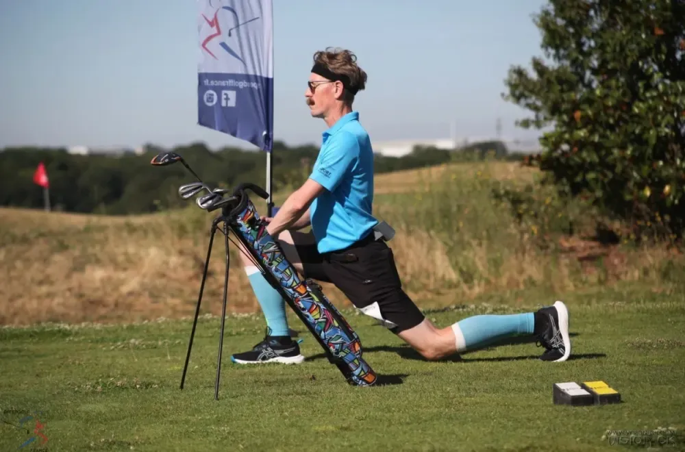 A competitor stretches beside a golf bag at the French Speedgolf Open.