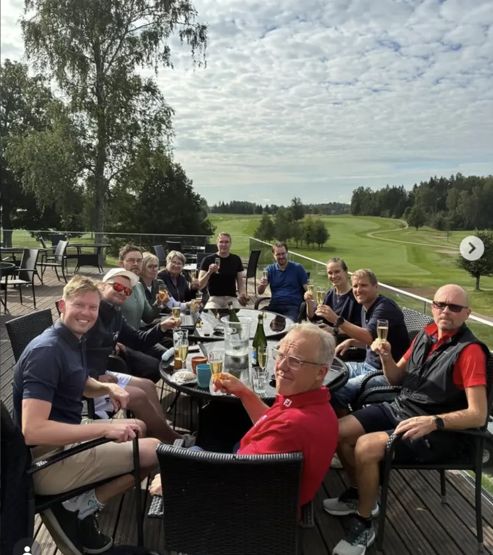 Speedgolfers celebrate over drinks on a clubhouse terrace.