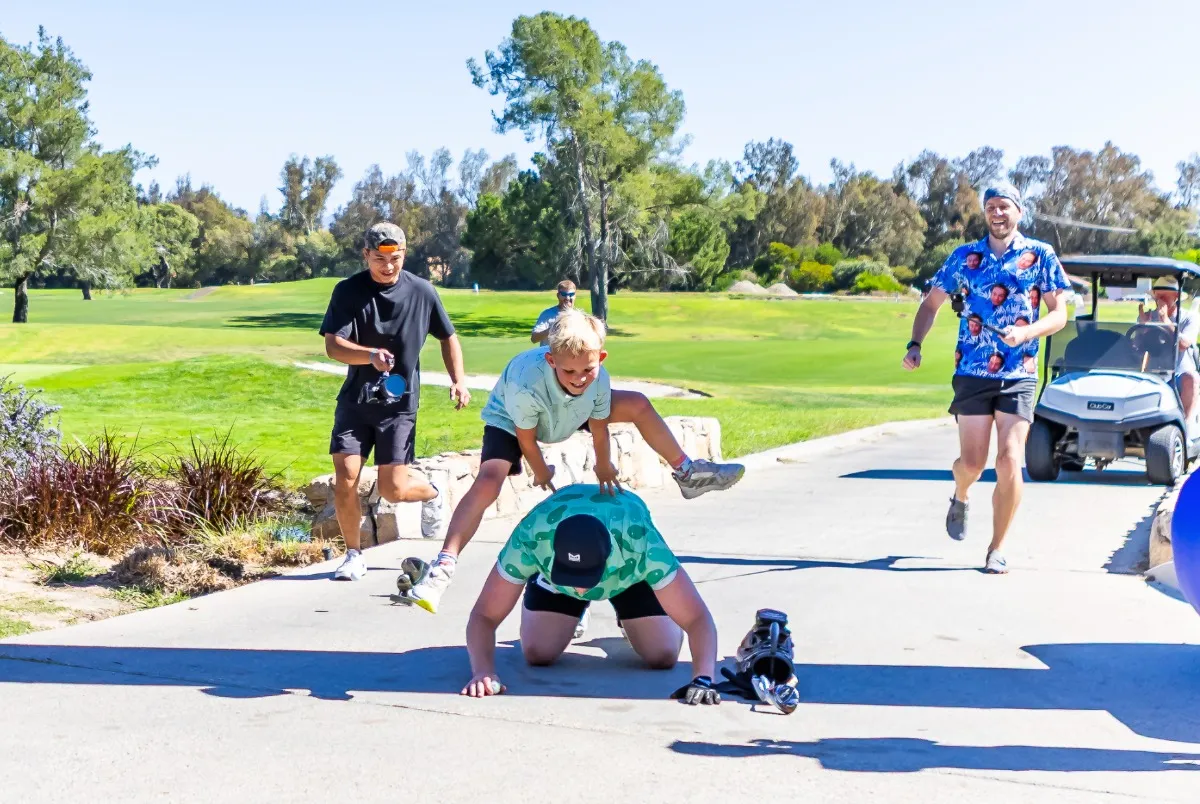 Speedgolfers run and celebrate beside golf carts during an event at Temecula Creek Golf Club.