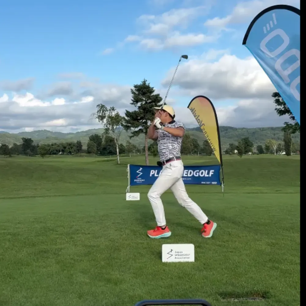 A speedgolfer hits a tee shot at a Japanese speedgolf event.
